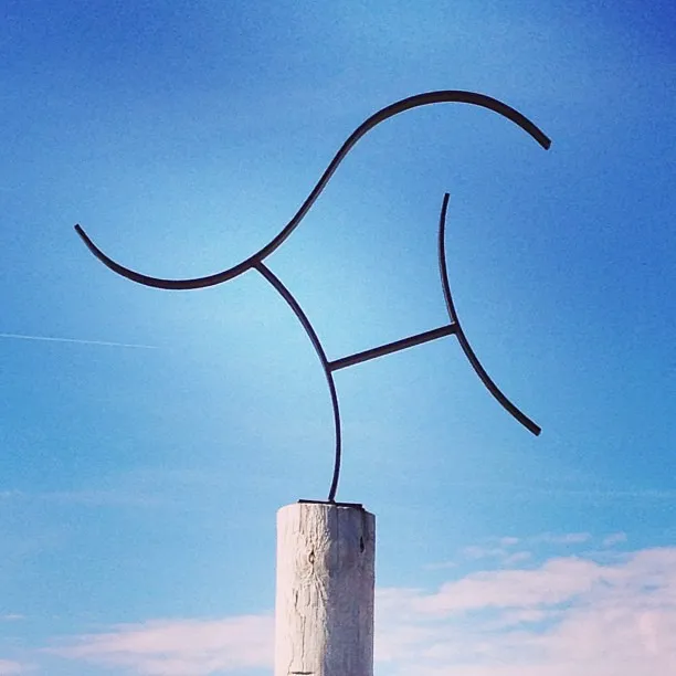 Sweeping view of Sand Hills Golf Club's rolling dunes and native grasses at golden hour
