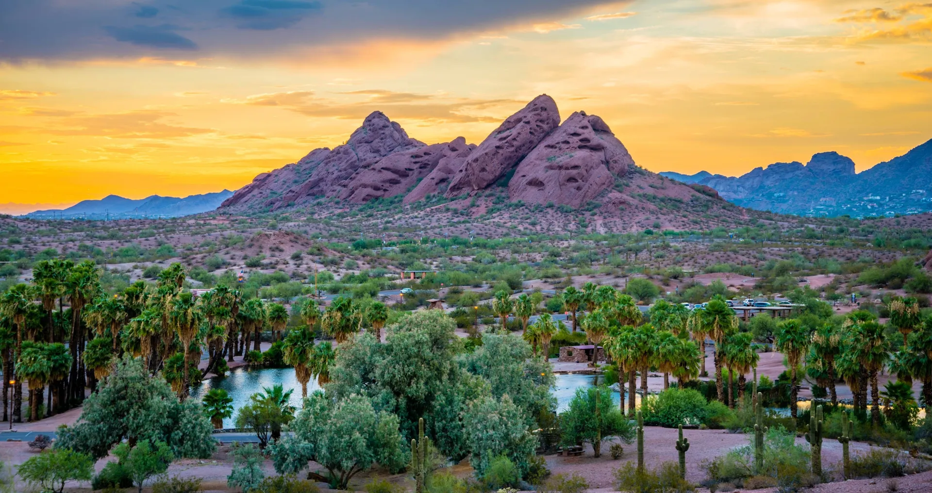 Emerald fairway winding through saguaro cacti and ancient granite boulders in the Sonoran Desert north of Scottsdale